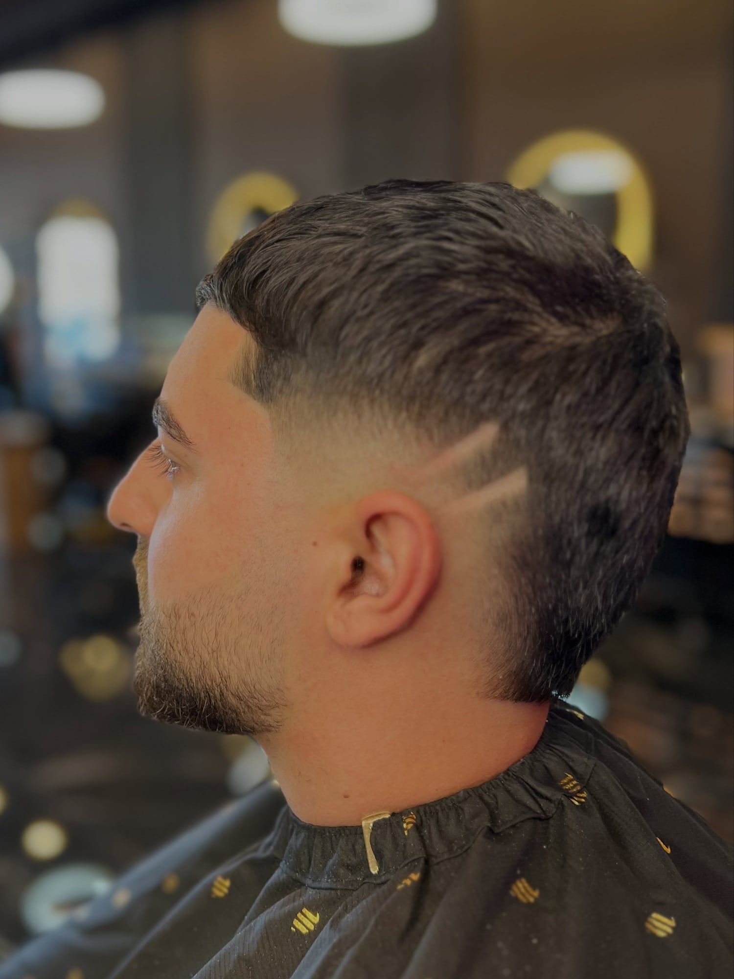 A low taper with two razor lines, seen from behind the ear