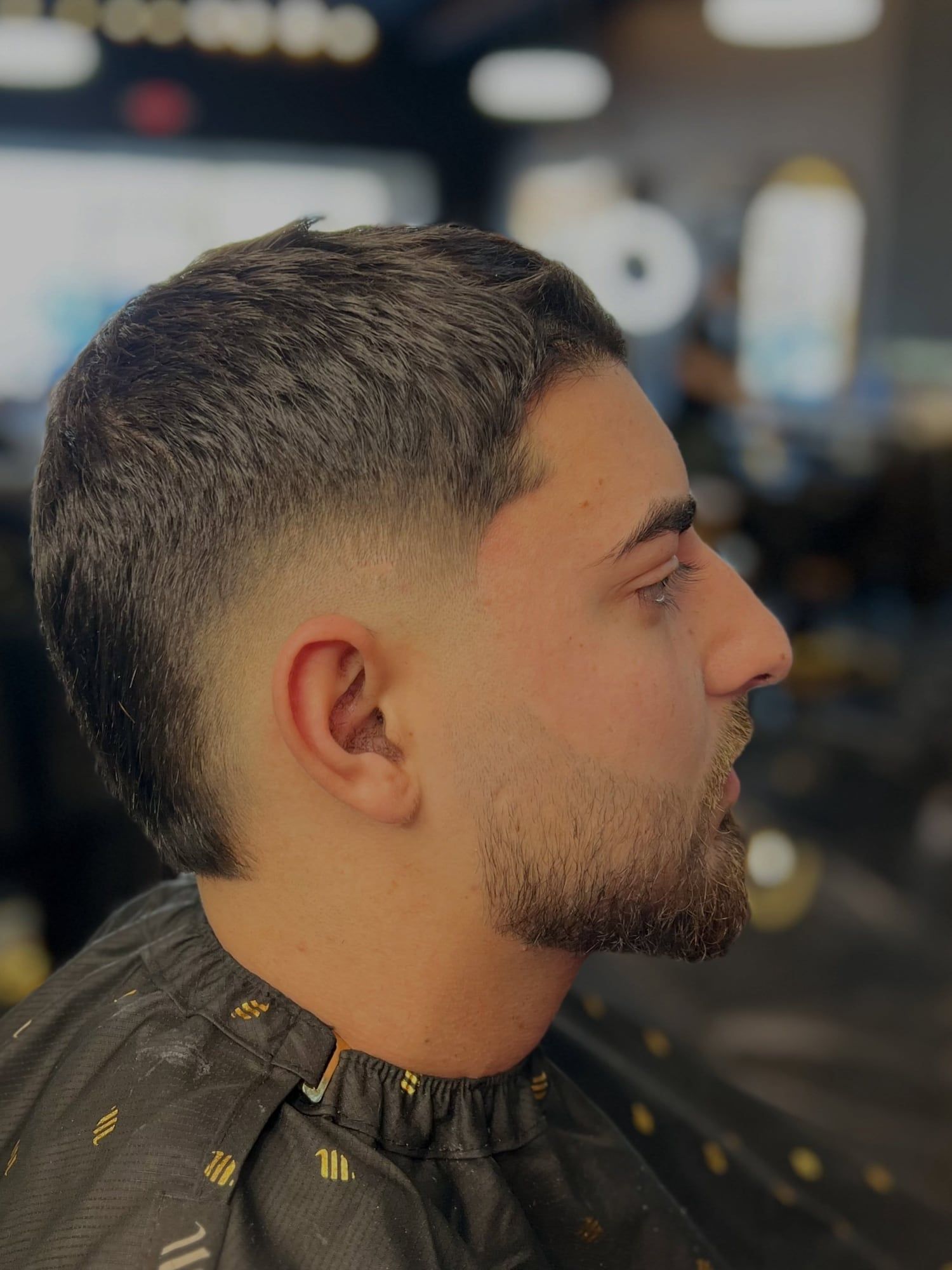 A client in profile with a taper fade blended into his beard